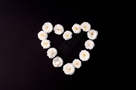 白小玫瑰的心框在黑色背景上母亲节情人节生日春天夏季概念平躺顶视复图片