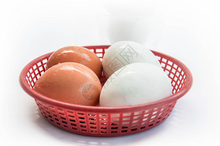 白色背景的红篮子新鲜棕蛋和白蛋图片