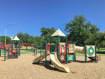 美国德克萨斯州达拉斯市中心被大树环绕的公园内色彩缤纷的城市游乐场图片