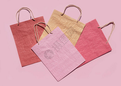 粉红色背景的彩色纹理纸购物袋最小的时尚购物在线概念复制空间图片