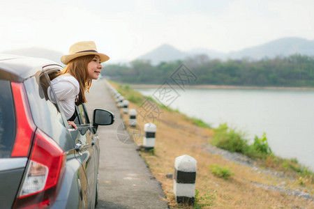 年轻的亚洲女游客在公路旅行度假时在窗外看风景女乘客感图片