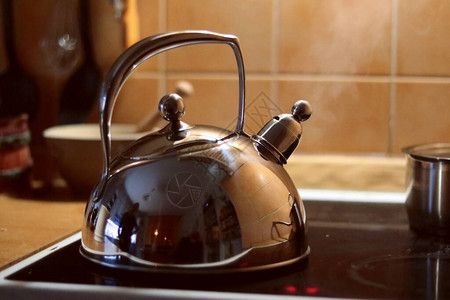 经典的金属茶壶在的火锅上开水图片
