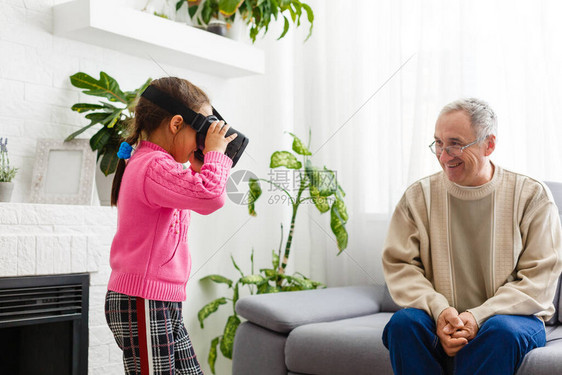 身着VR虚拟现实头戴与祖父母交接的儿童数字复合图片