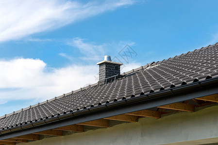 屋面防水一栋独户住宅的屋顶覆盖着一块新的无烟煤瓷砖背景