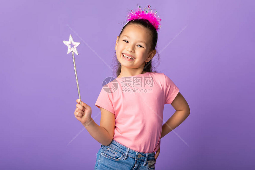 小公主概念小亚洲小子穿戴王冠拿着魔棍微笑着在紫图片