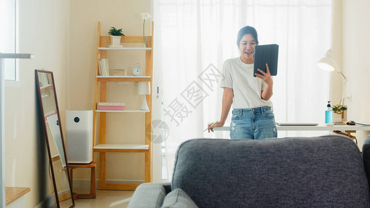 亚洲自由职业女商人休闲装使用平板电脑工作电话视频会议图片
