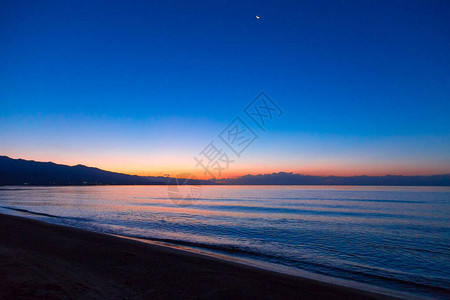 海上太阳的黎明山后初升的太阳背景图片