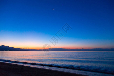 海上太阳的黎明山后初升的太阳背景图片