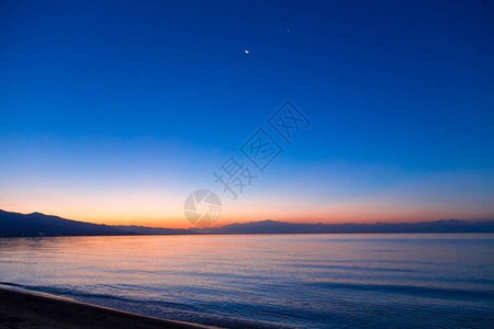 海上太阳的黎明山后初升的太阳背景图片