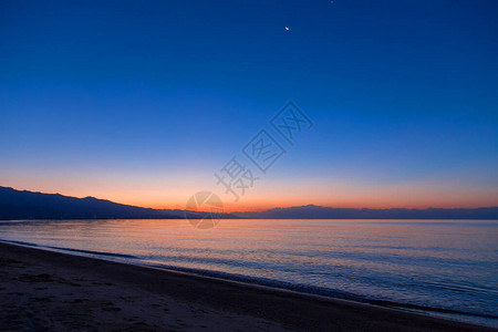 海上太阳的黎明山后初升的太阳背景图片