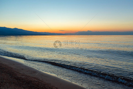 海上太阳的黎明山后初升的太阳图片