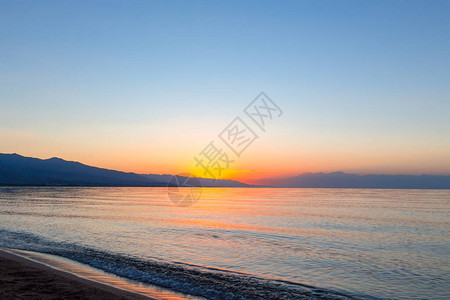 海上太阳的黎明山后初升的太阳背景图片