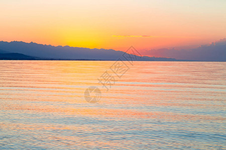 海上太阳的黎明山后初升的太阳背景图片