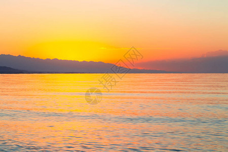 海上太阳的黎明山后初升的太阳背景图片