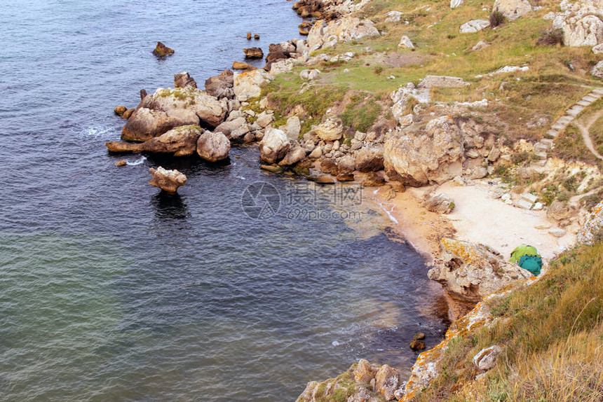 海边有岩石和沙滩阳光明媚海水清澈天空晴朗而蓝图片