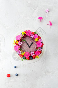 时钟式蛋糕装饰着鲜花垂直方向顶部视野平坦的躺下图片