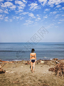 年轻的女孩站在沙滩上图片