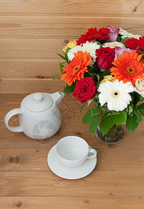 木制桌上的陶瓷茶壶和杯子花瓶图片