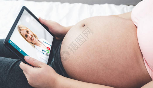 医生远程医疗服务在线视频与孕妇进行产前护理在家中使用在线移动设备连接到互联网进行实时视频通话的远程医生图片