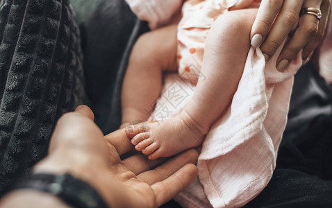 新生儿双脚和父母抱住她的近视相片背景图片