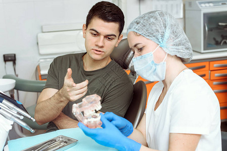 牙医告诉他的病人即将进行的治疗牙科治疗的概念图片