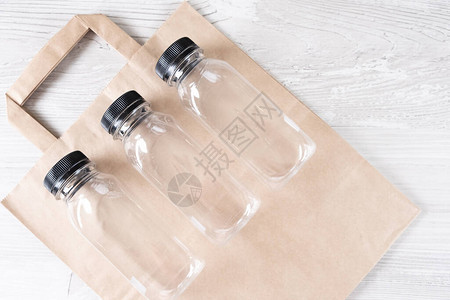 三个塑料瓶您的标志的地方灰色背景的环保食品包装和棉质生态袋图片