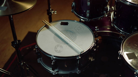 特写专业乐器爵士乐队在录音室的鼓套件鼓槌躺在鼓上带图片