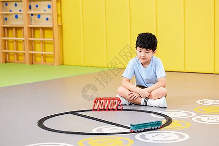 室内玩玩具火车的小男孩图片