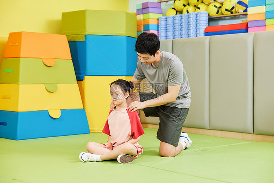 教练指导小女孩进行体态训练图片