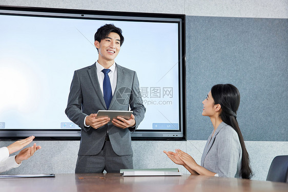 会议室阐述工作内容的年轻商务白领图片