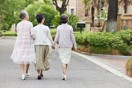 春天女性老年人相伴户外散步背影背景