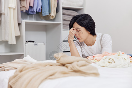 简易衣柜收拾衣物感到烦躁的居家女性背景