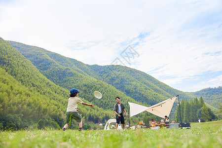 一家人草地玩耍父子户外露营玩飞盘背景