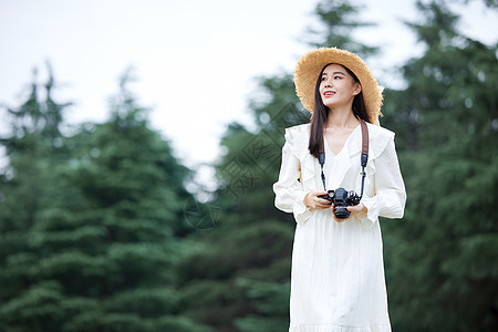 年轻美女拿着相机拍照高清图片