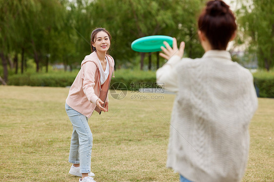 秋季在户外玩飞盘的女性图片