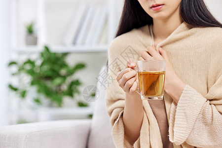 喝茶女生捧着姜茶裹着围巾的女性特写背景