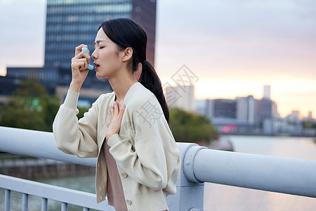 室外青年女性使用哮喘喷雾高清图片