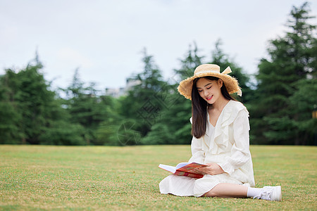 年轻美女户外草坪阅读图片