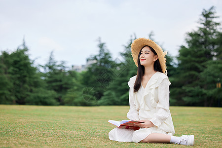 文艺女年轻美女户外草坪放松阅读背景