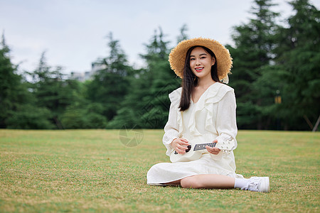 青年美女草坪上谈尤克里里图片