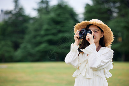 年轻美女手拿相机拍照高清图片