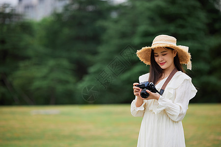 青年美女手拿相机拍照图片