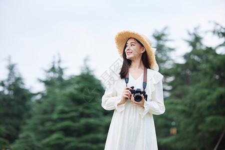 青年文艺美女手拿相机拍照图片