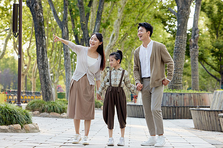幸福的一家三口在公园里散步图片