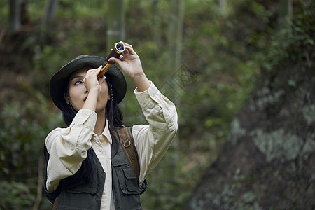 年轻美女户外游玩用望远镜看风景图片