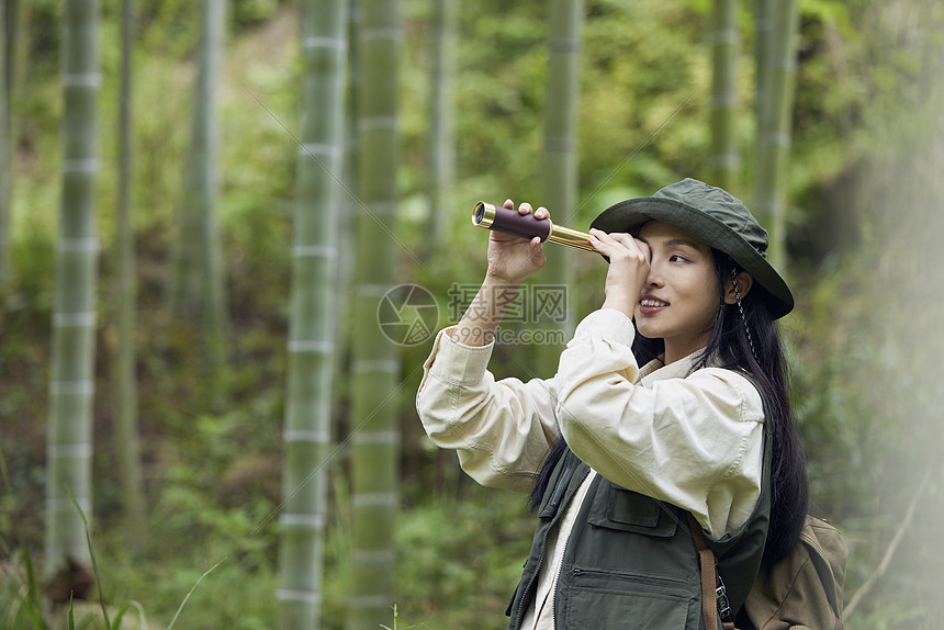 年轻美女户外游玩用望远镜看风景图片