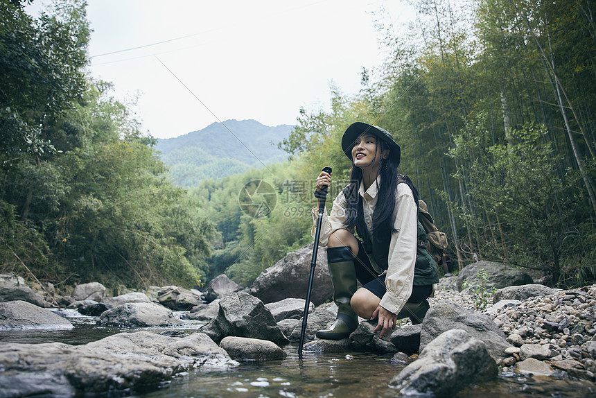 年轻女性在户外溯溪玩水图片