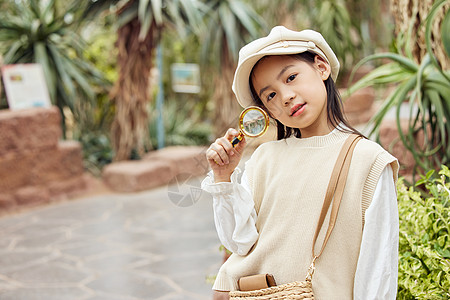 在植物园手拿放大镜的小女孩背景