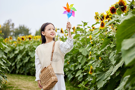 向日葵花田里玩耍的小女孩高清图片