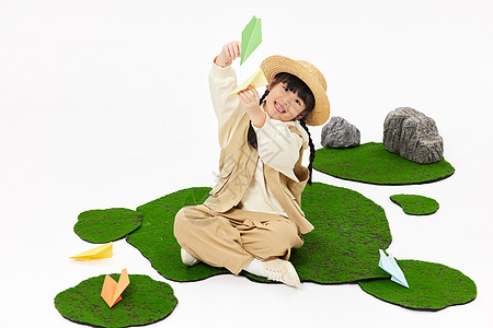 日系小女孩草地上飞纸飞机形象图片